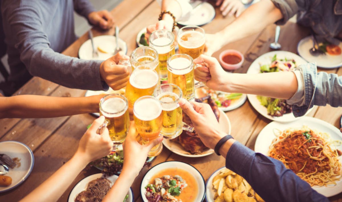 a group of people sitting at a table with a plate of food