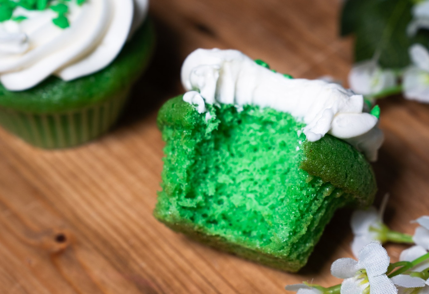a green cupcake with white frosting