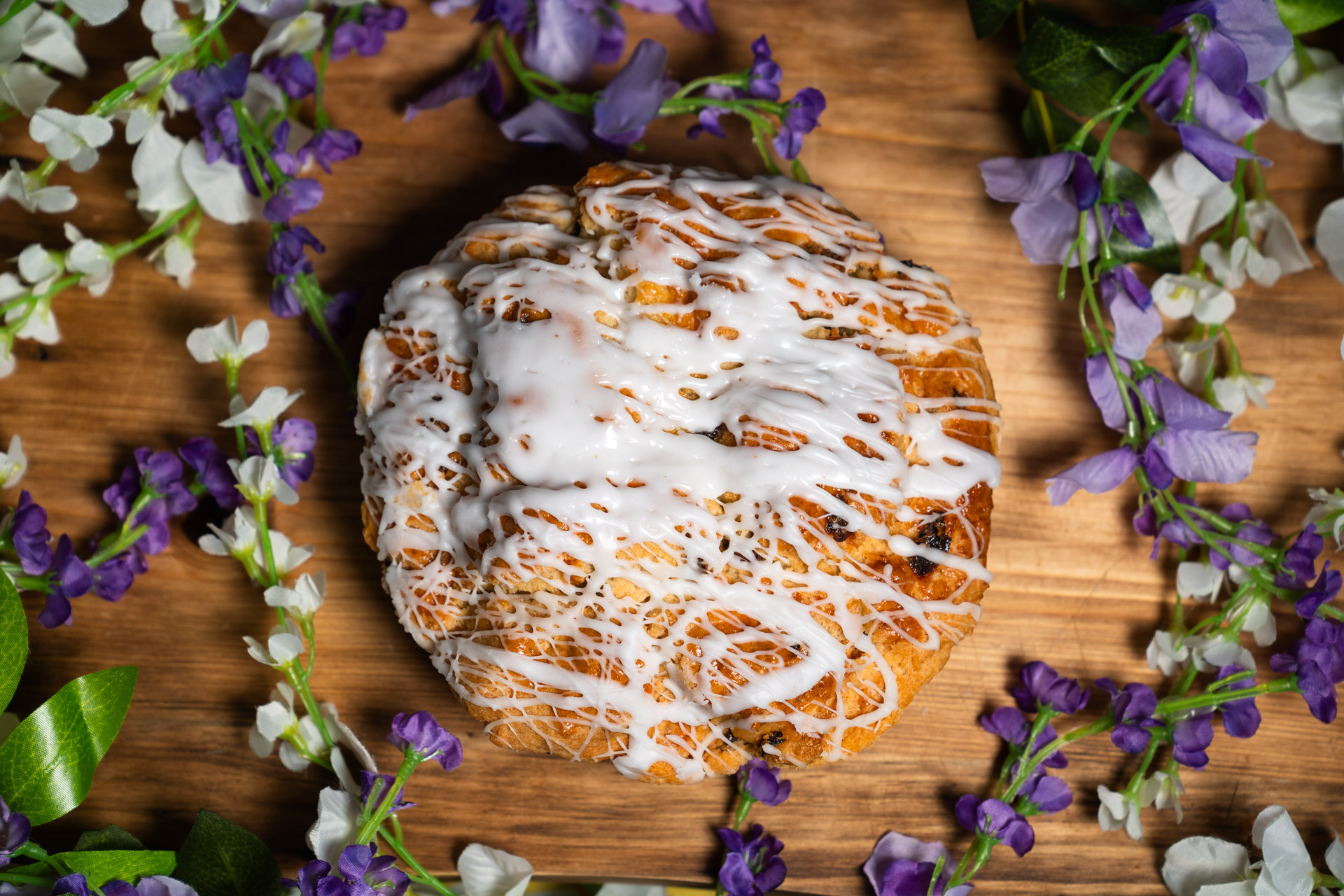 a pastry with white frosting and purple flowers around it