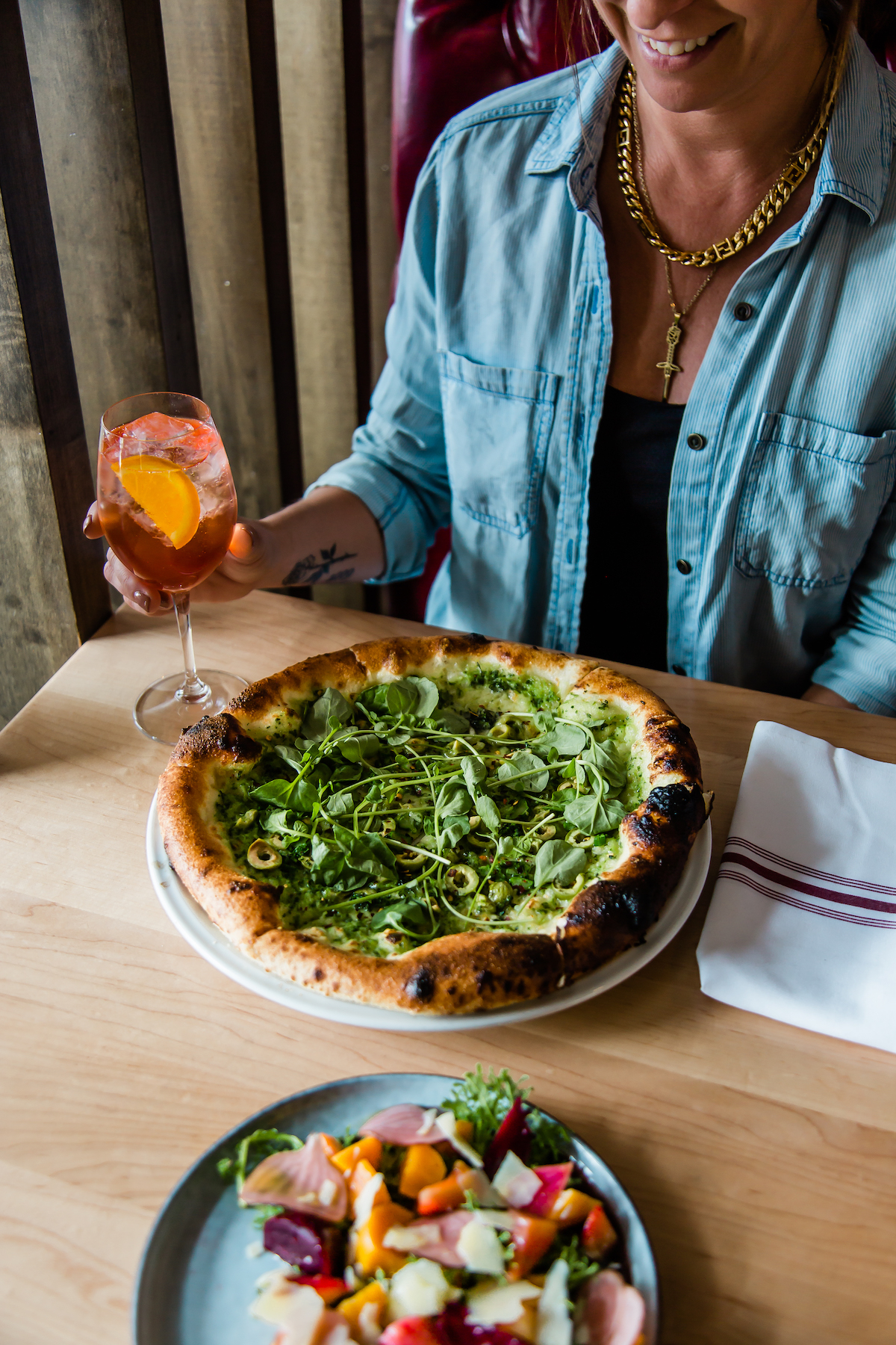 a woman sitting at a table with a plate of pizza