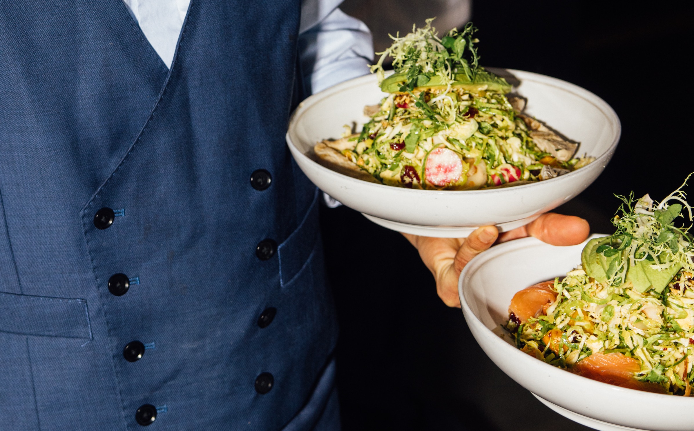 a person holding a bowl of salad