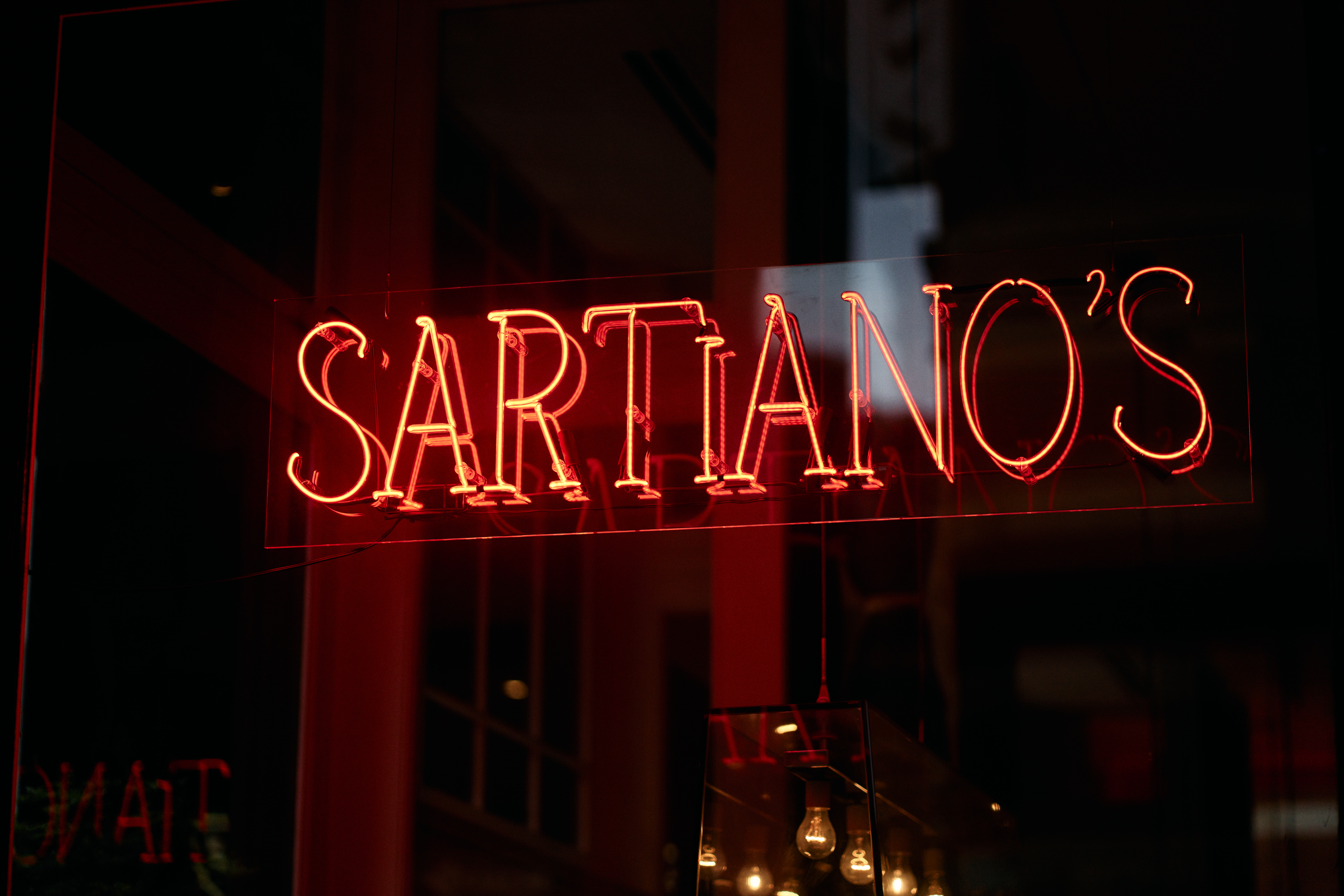 a sign on the side of a building lit up at night