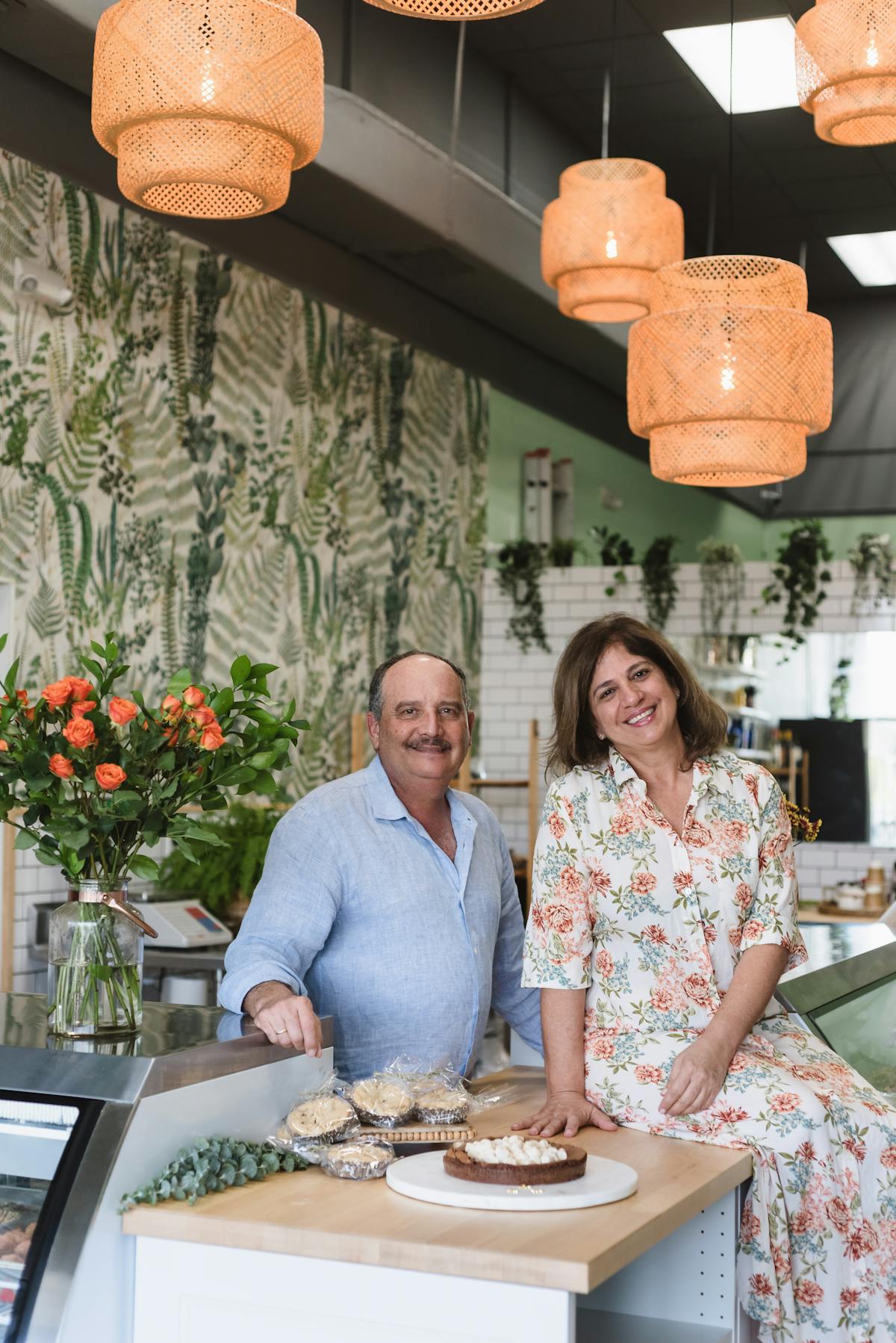 a man and a woman standing in front of a cake
