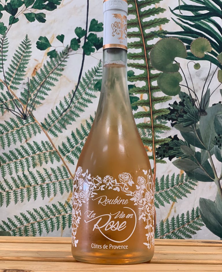 a bottle of beer next to a vase on a table