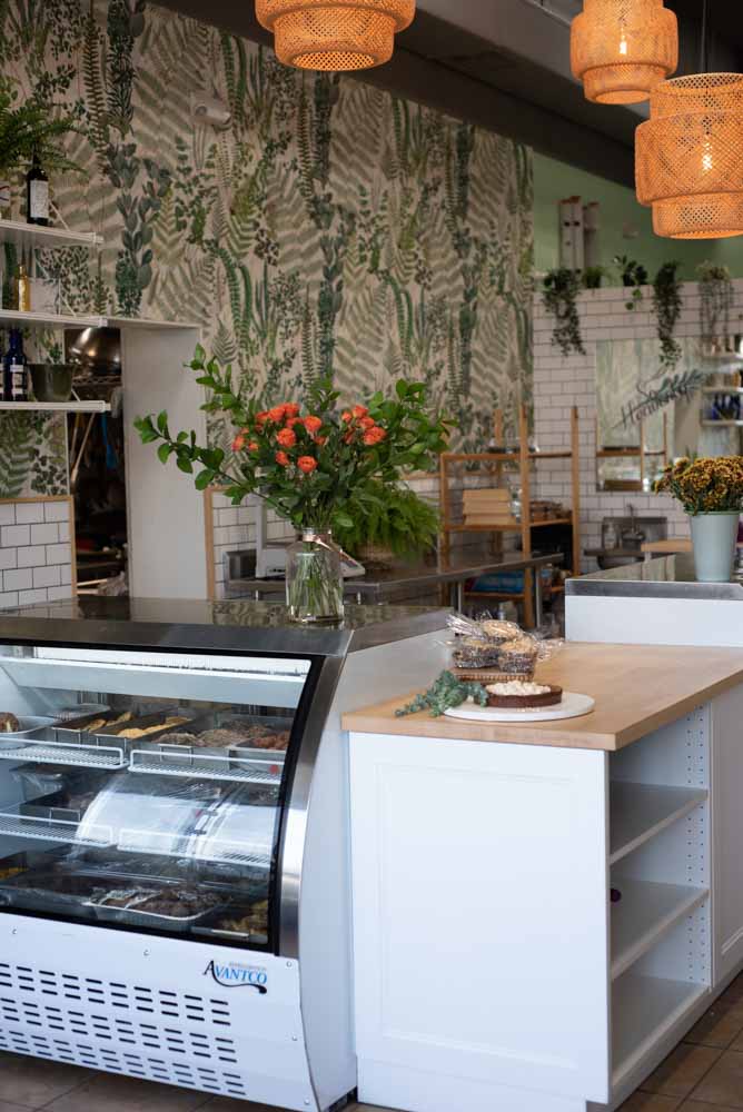 a flower vase in a glass case in a bakery