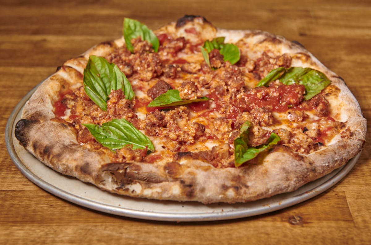 a pizza sitting on top of a wooden table