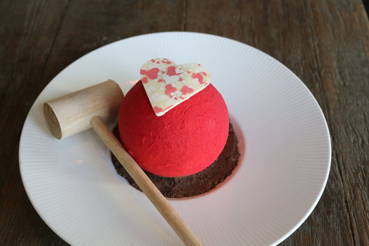 a plate with a piece of cake sitting on top of a wooden table