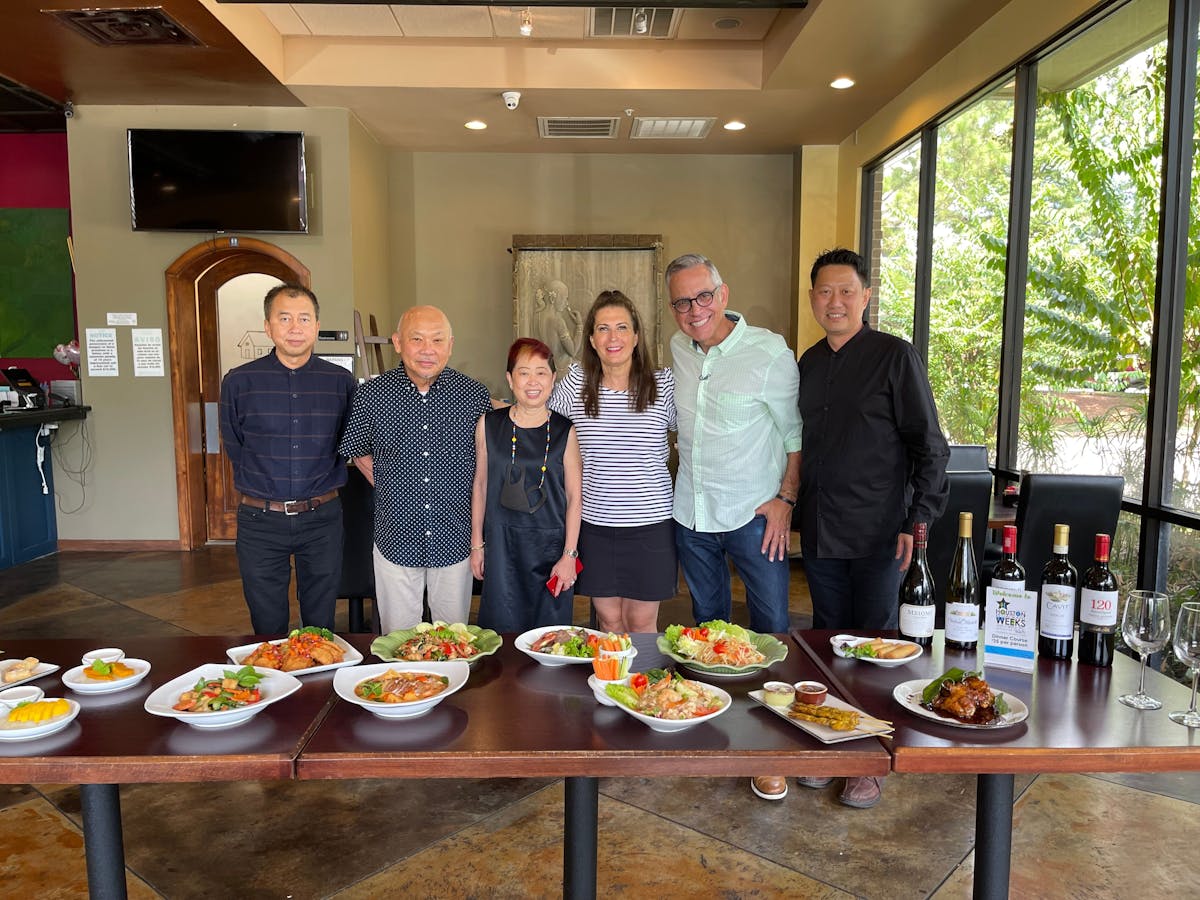 a group of people standing around a table eating food