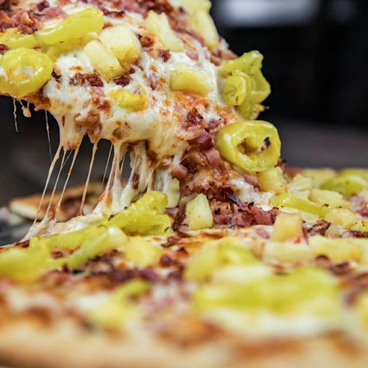 a close up image of a jalapeno and meat pizza