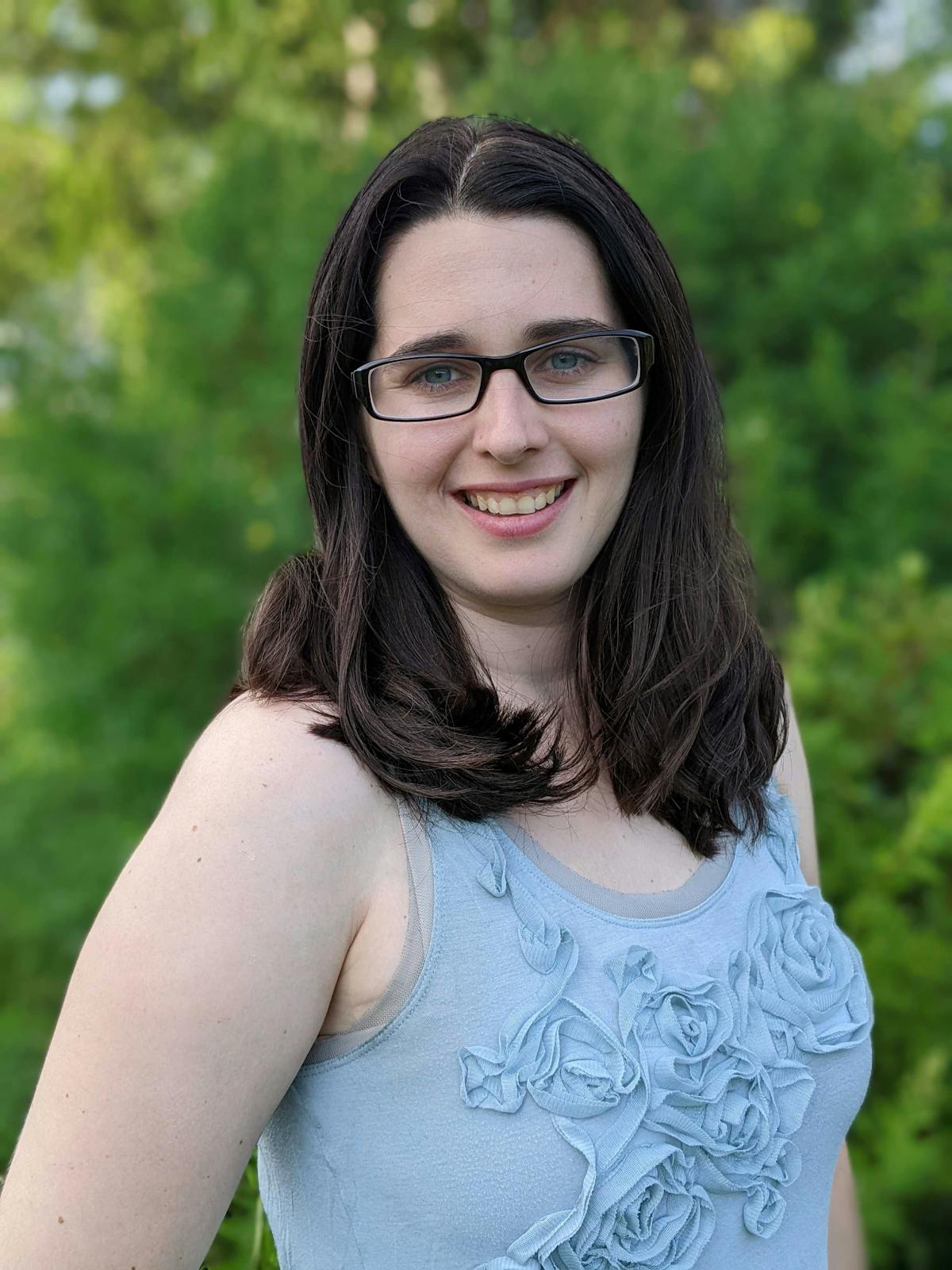 a person wearing glasses and smiling at the camera