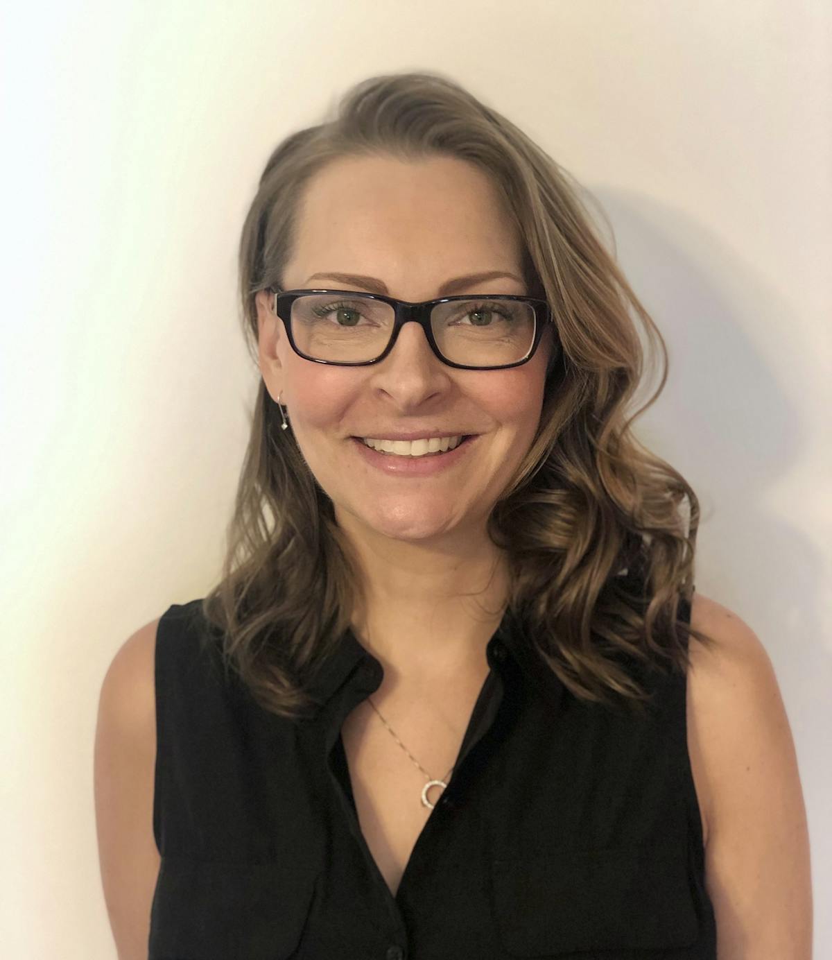a woman in glasses looking at the camera