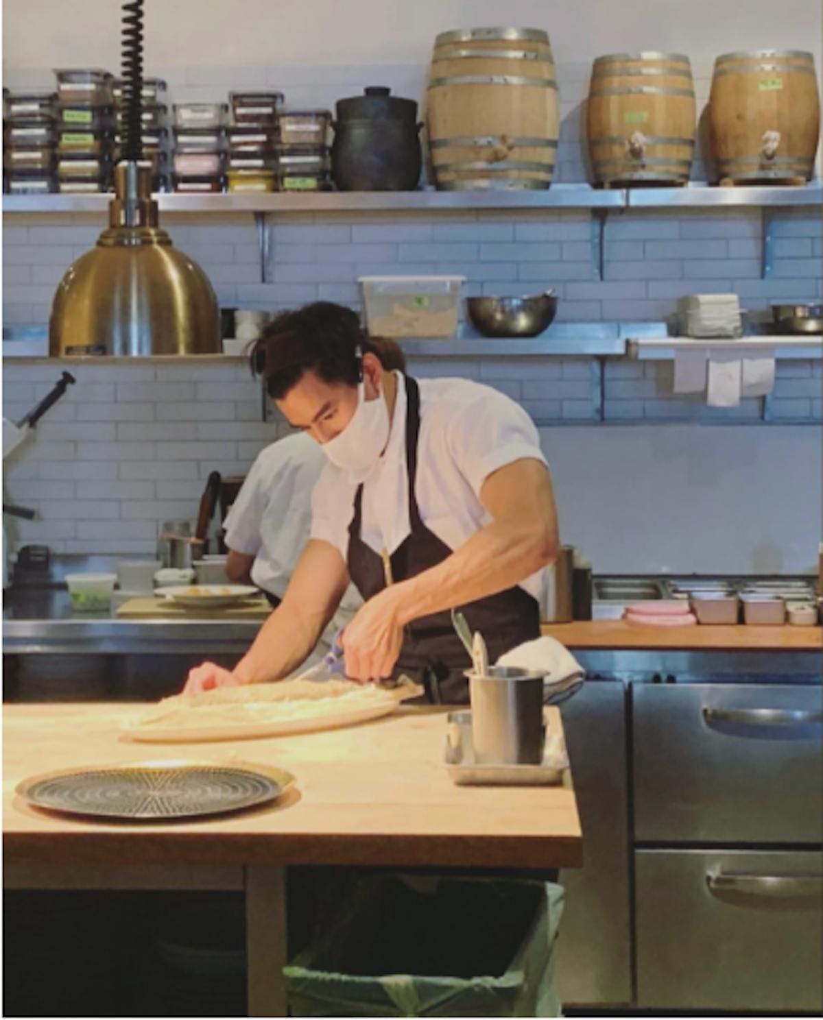 a person sitting on a kitchen counter preparing food