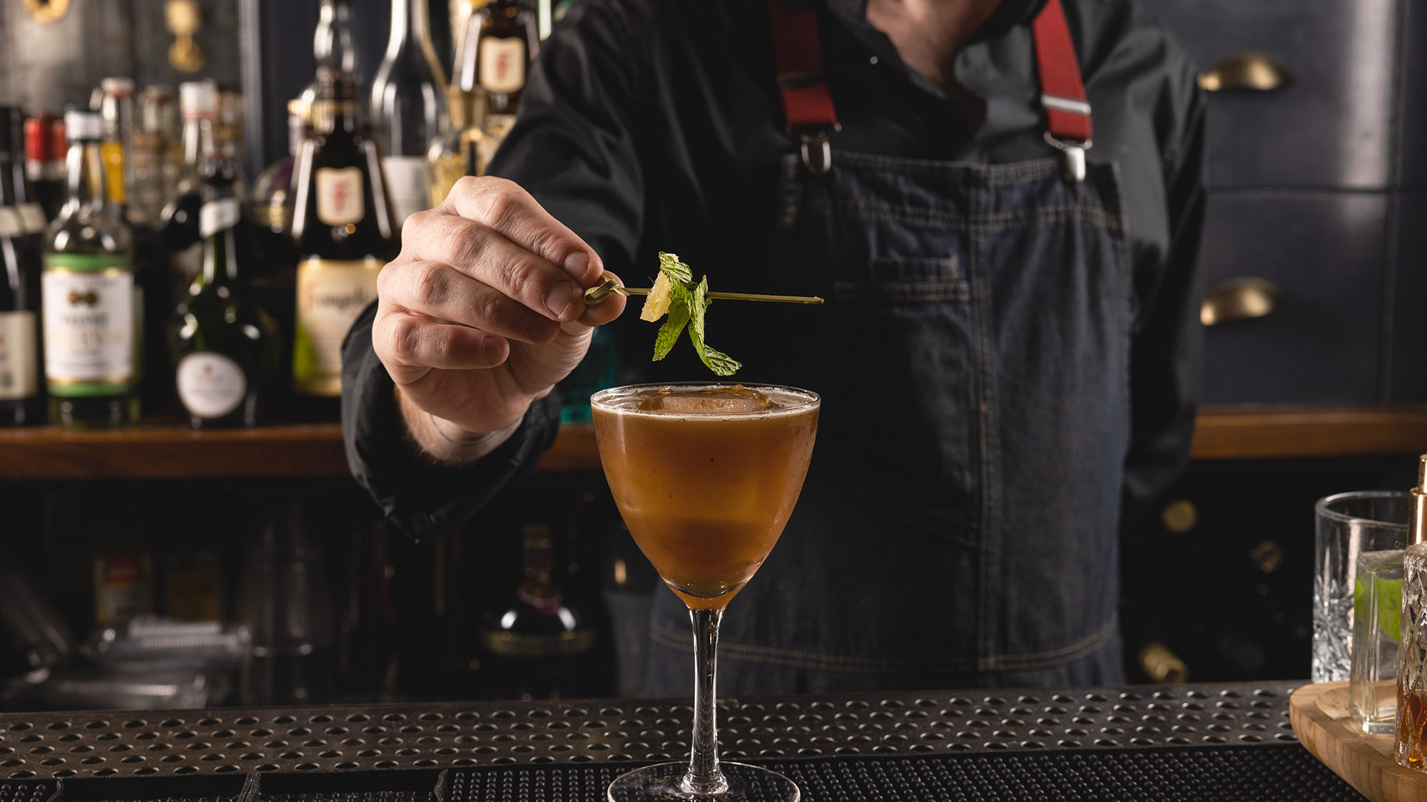 Bartender placing the garnish for Trace of Balsamic hand made cocktail at The Independent in Midtown Manhattan