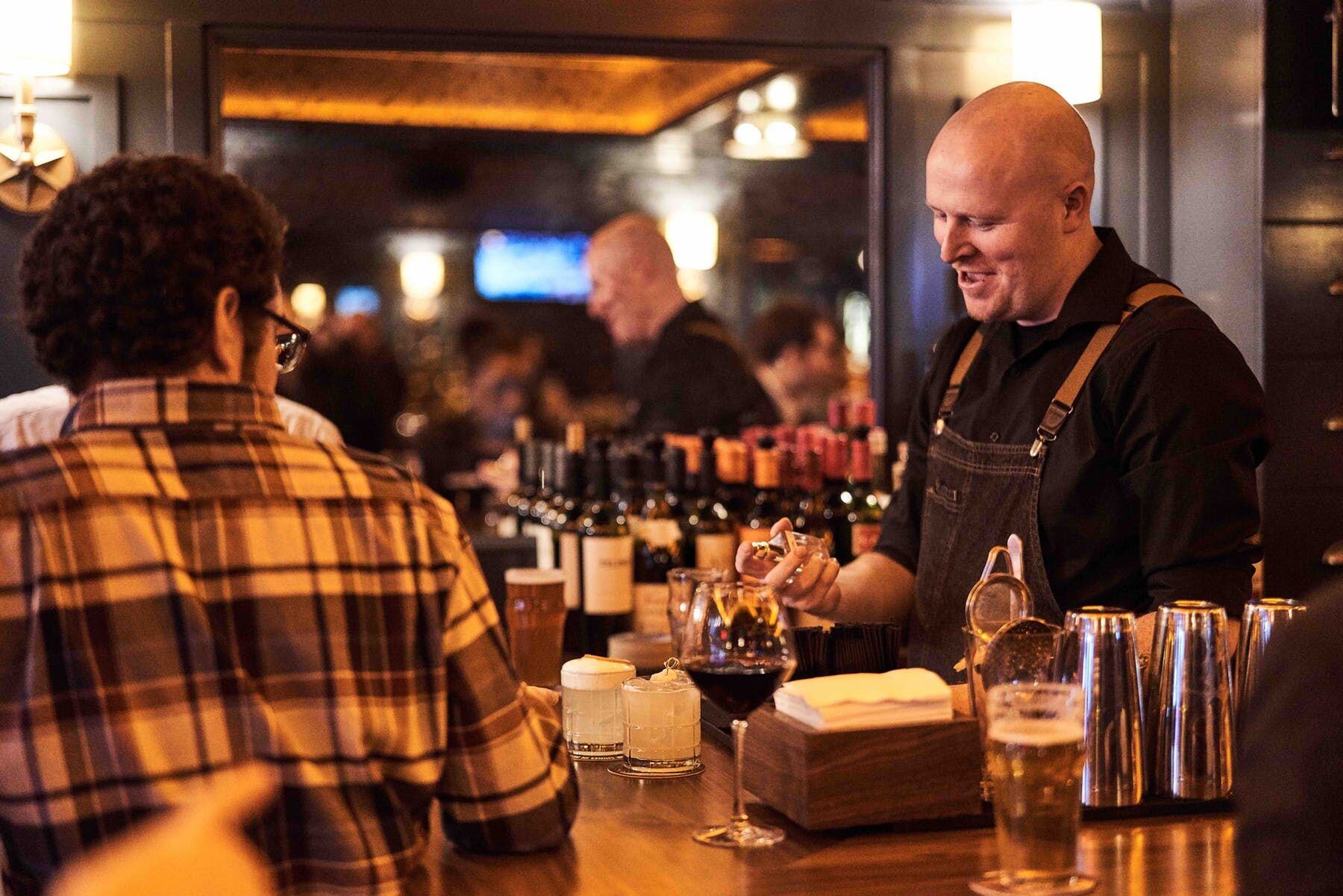 guests chatting with the bartender at The Independent in Midtown, Manhattan