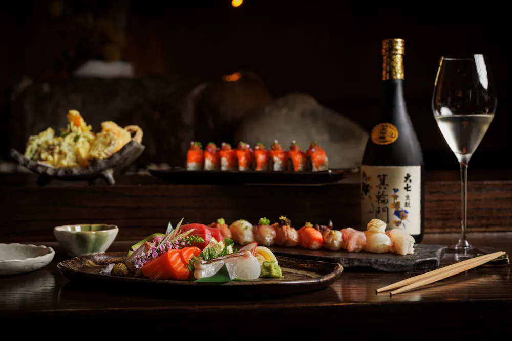 a plate of sushi and a bottle of wine