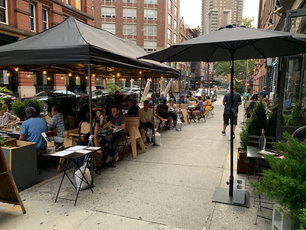 a group of people sitting at a table in front of a building