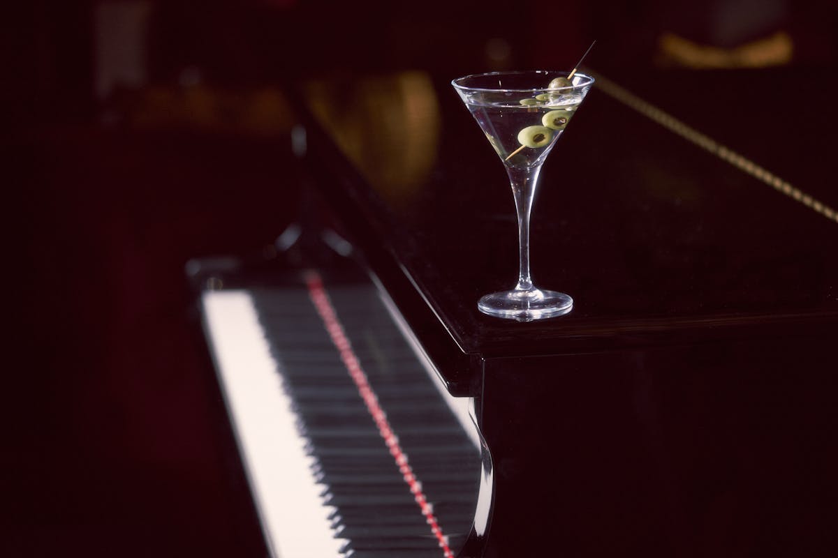 a piano next to a glass of wine