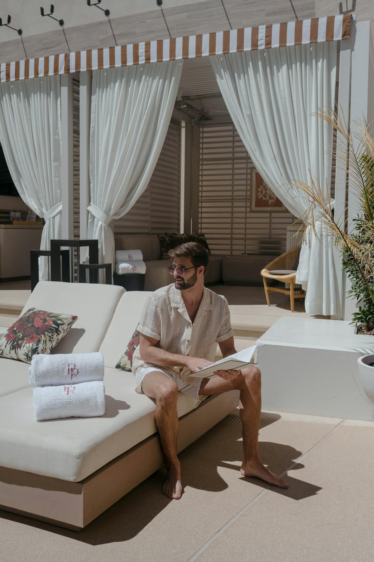 a person sitting at a table in front of a curtain