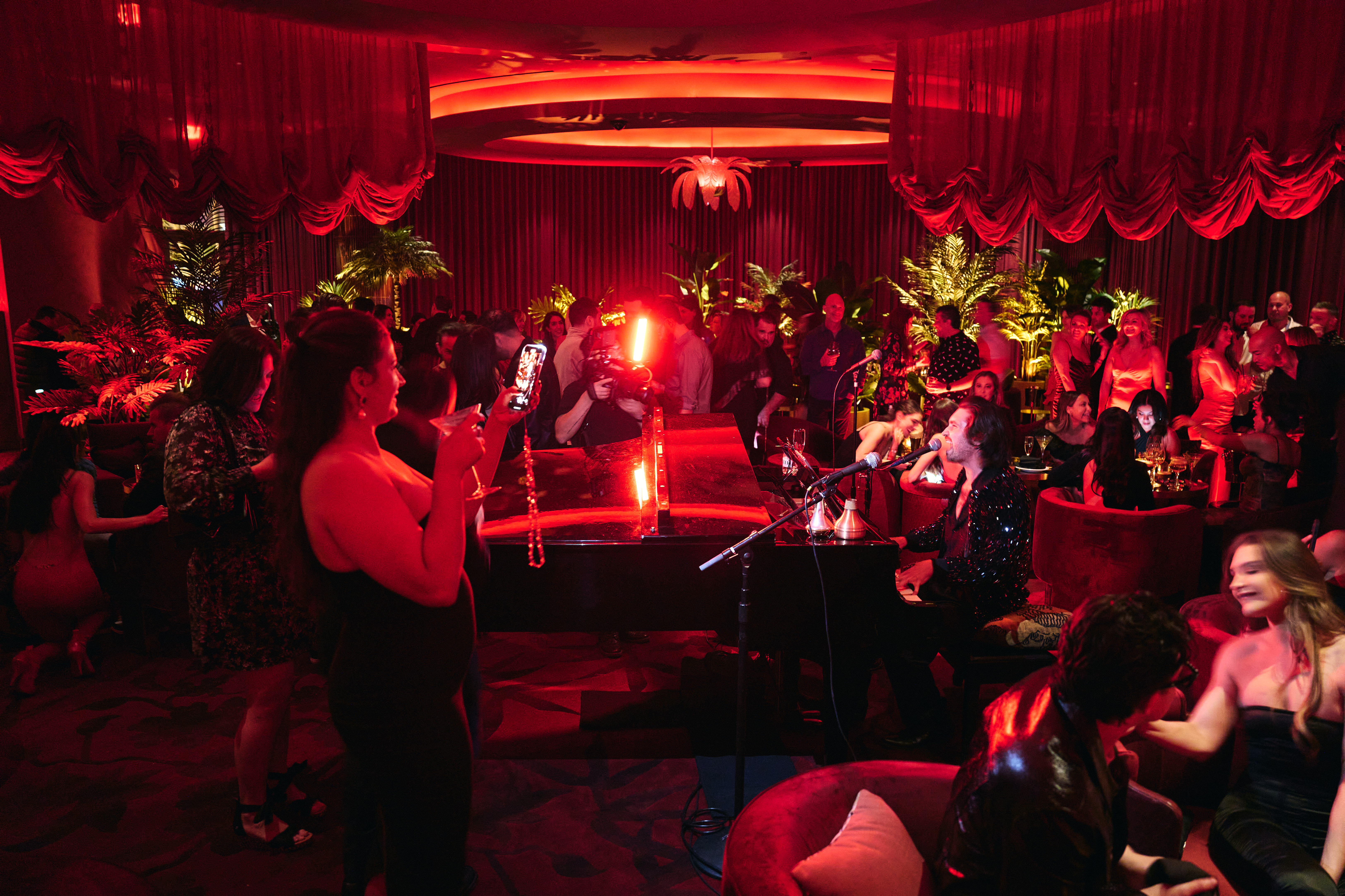 a group of people sitting around a christmas tree in a dark room