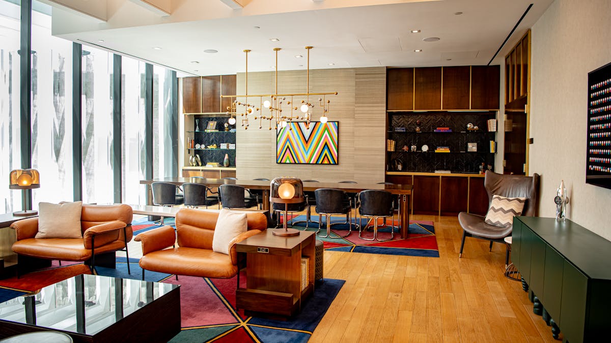 A hotel lobby featuring a spacious design with a large glass wall, allowing natural light to illuminate the area