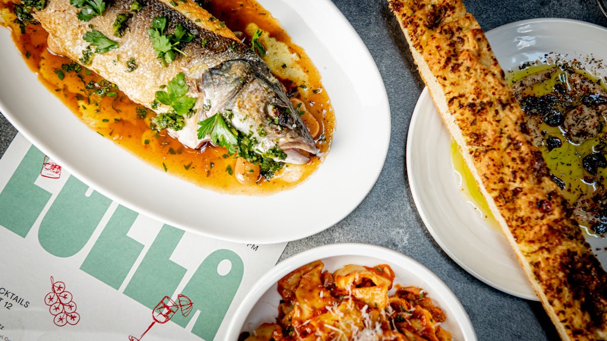 A table set with various plates of food and fresh bread, creating an inviting dining atmosphere