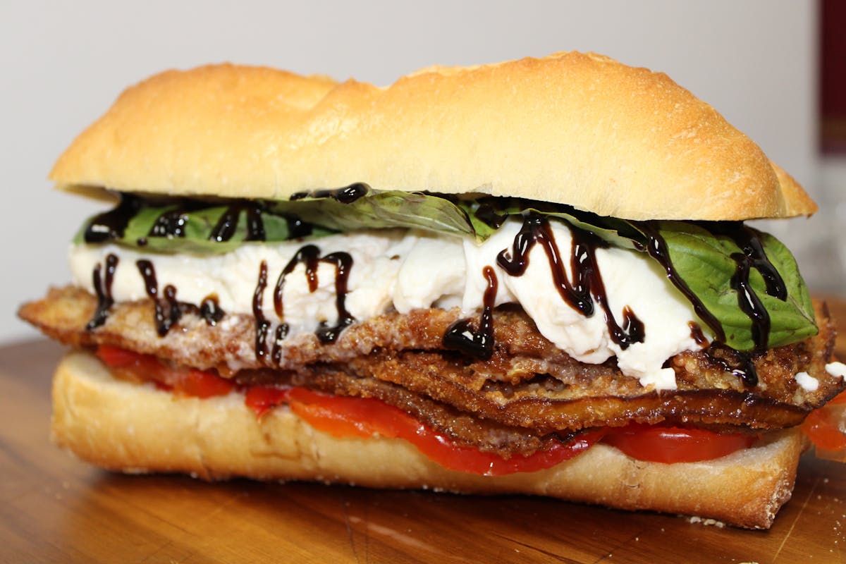 a sandwich sitting on top of a wooden cutting board