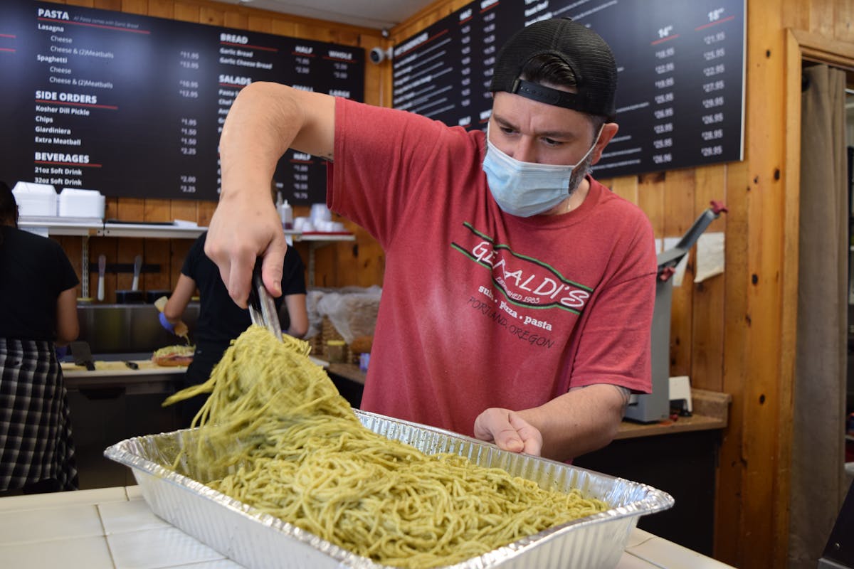 a person preparing a catering order for pasta