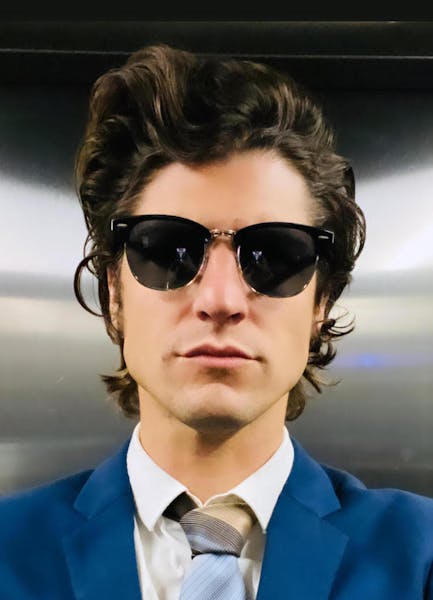 a person wearing sunglasses and a suit and tie