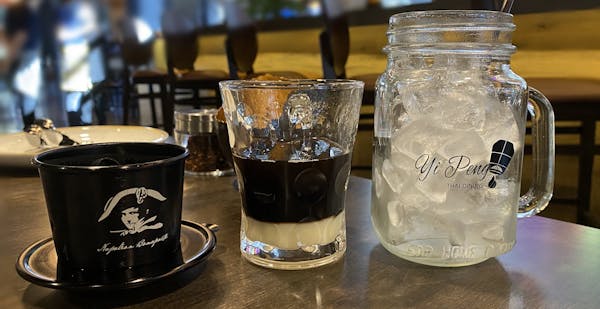 a cup of coffee and a glass of beer on a table