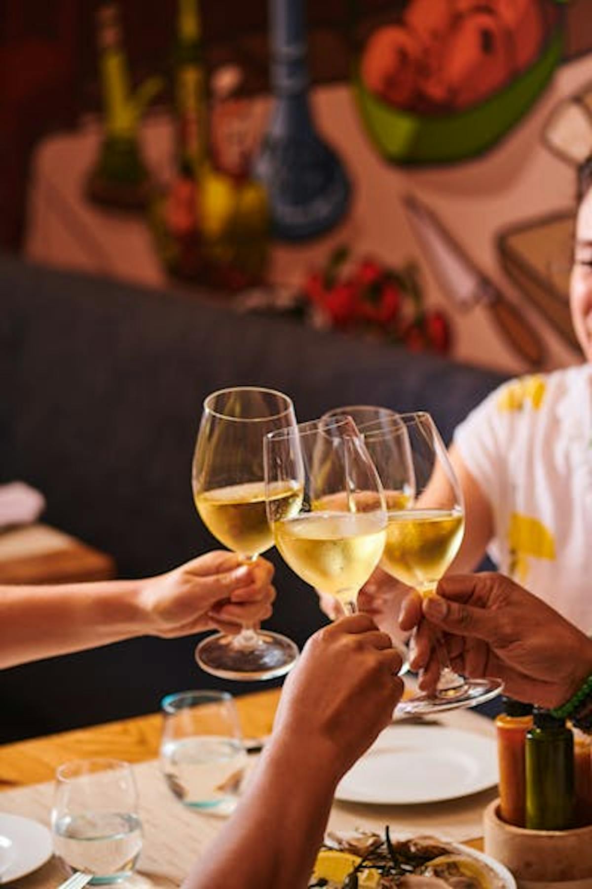 a person sitting at a table with wine glasses