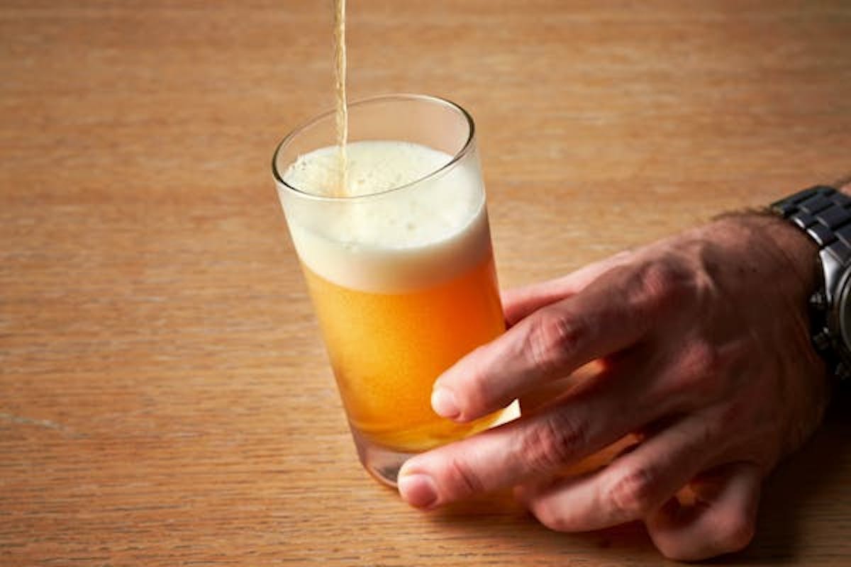 a person sitting at a table with a glass of orange juice