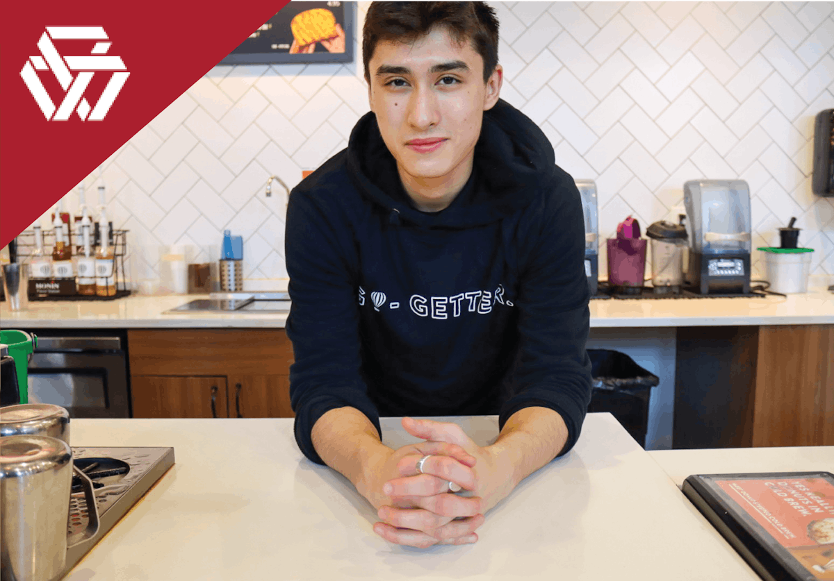 a man posing for the camera leaning against a kitchen counter