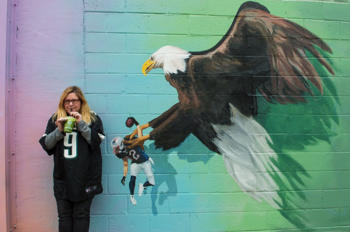 a person standing in front of a statue of a bird