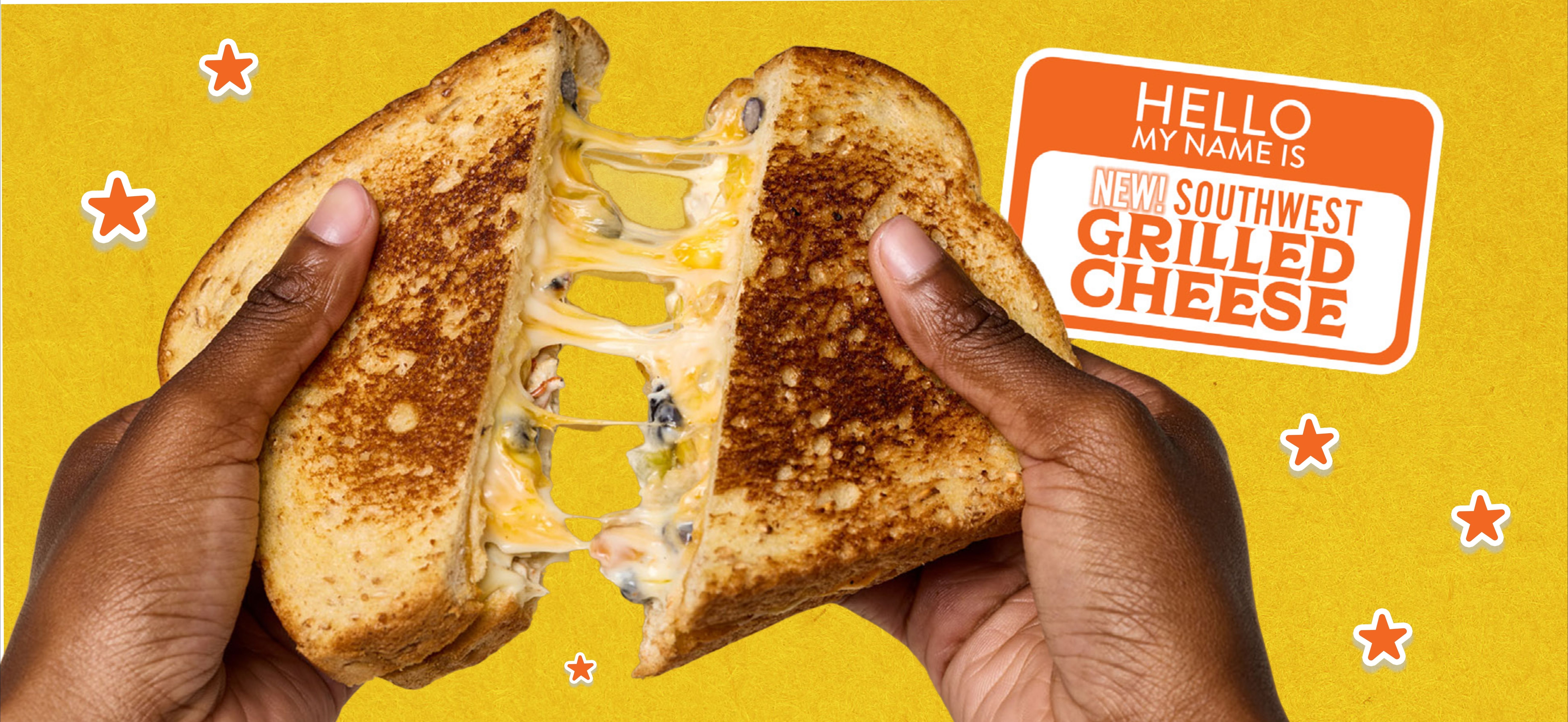 a hand holding a grilled cheese sandwich