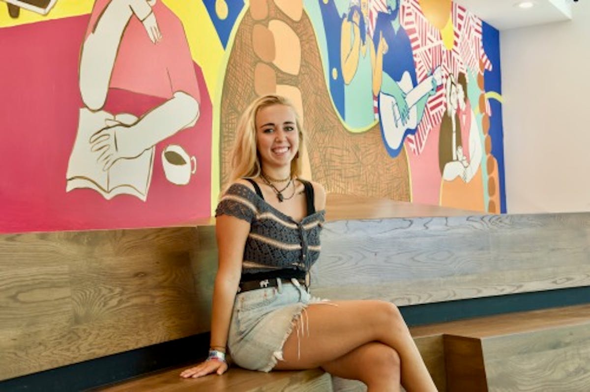 a woman sitting on a bench posing for the camera