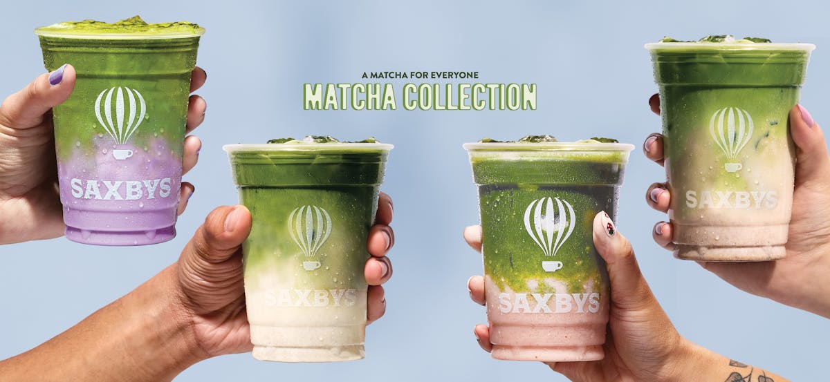 hands holding matcha lattes