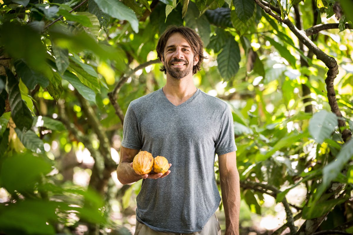 a man holding a banana tree