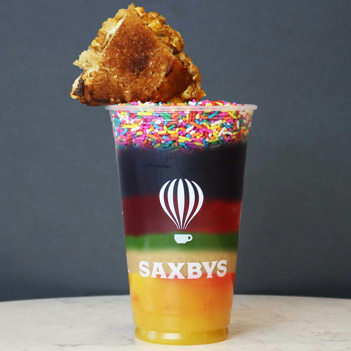 April Fools Drink inspired by 7 layer dip. layers: grilled cheese garnish, sprinkles, cold brew, raspberry tea, matcha, daily grind, vacay all day.