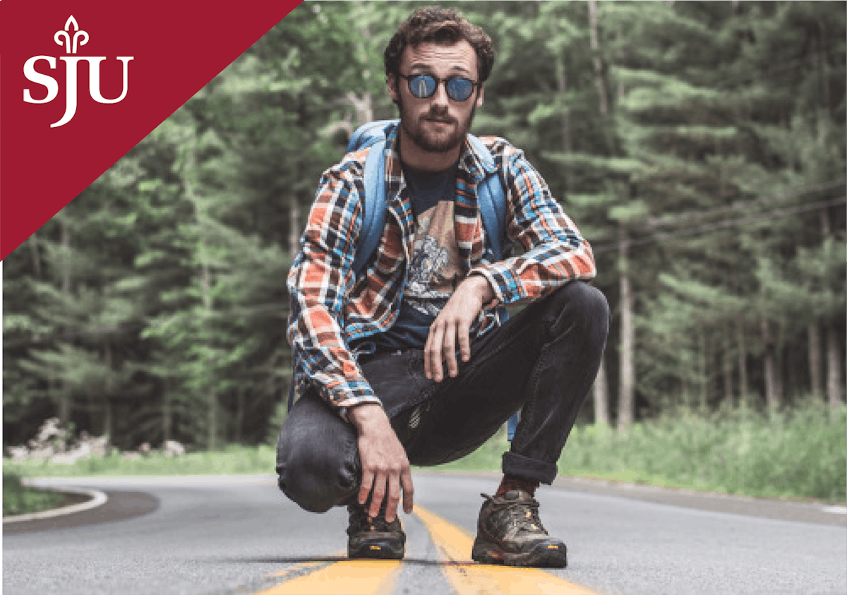 a man crouched on the side of a road