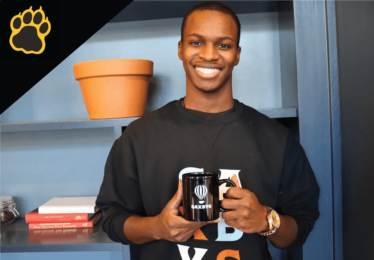 a man holding a coffee mug and smiling at the camera