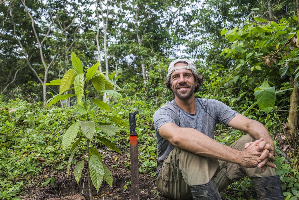 a man standing in front of a tree