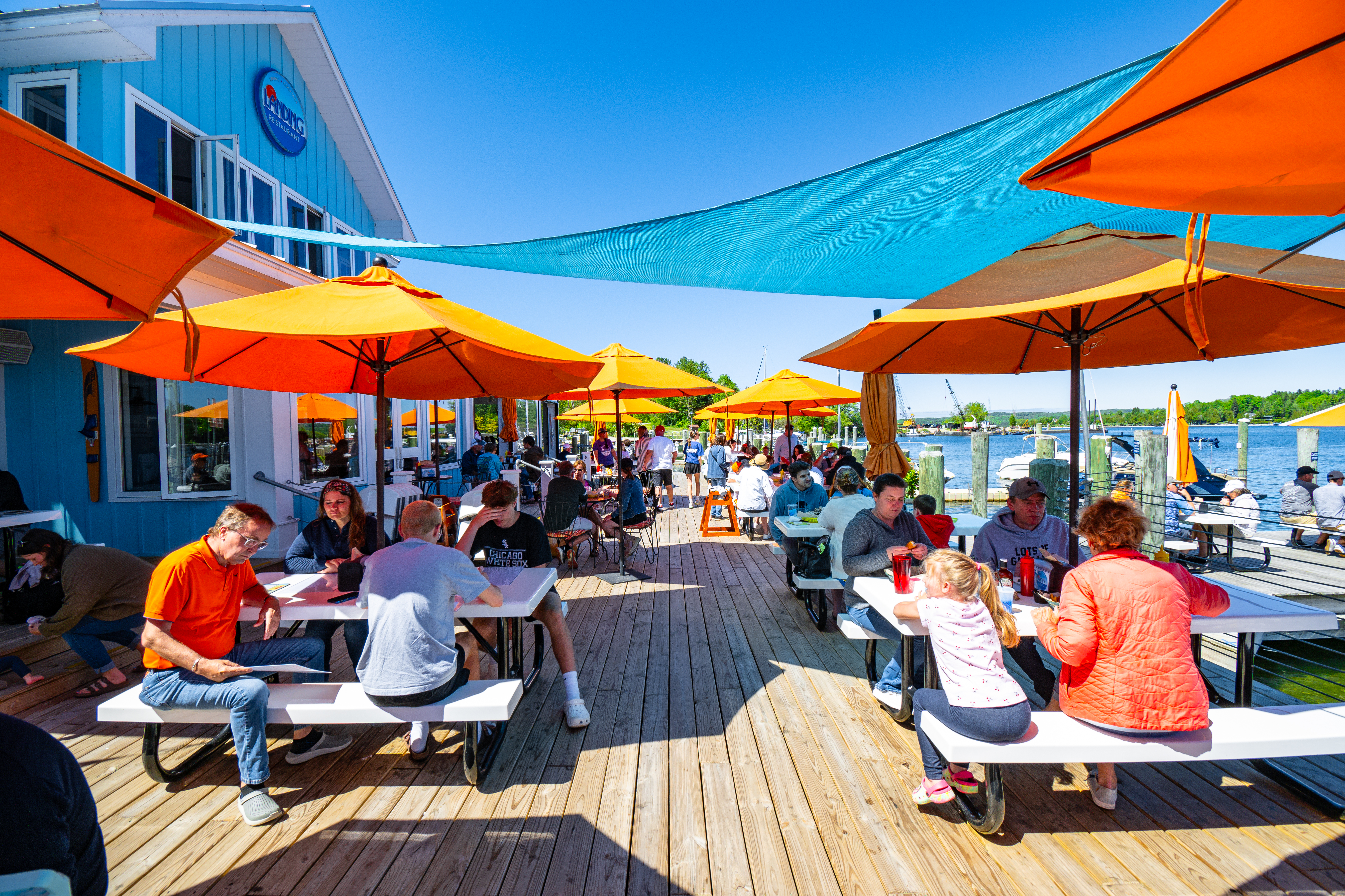 a group of people sitting at a table with an umbrella