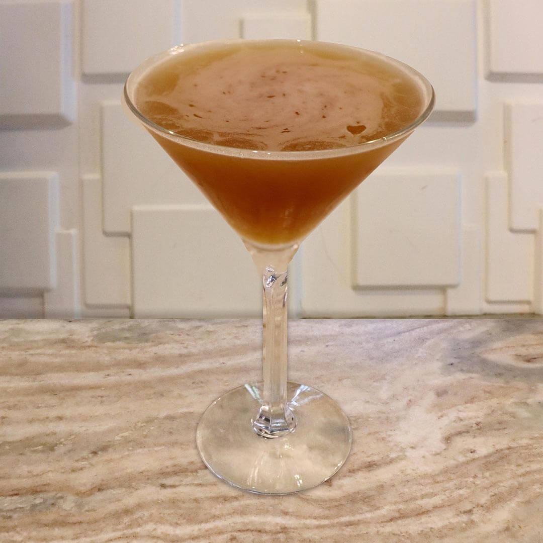 A bright orange, citrus-toned cocktail served in a chilled glass.