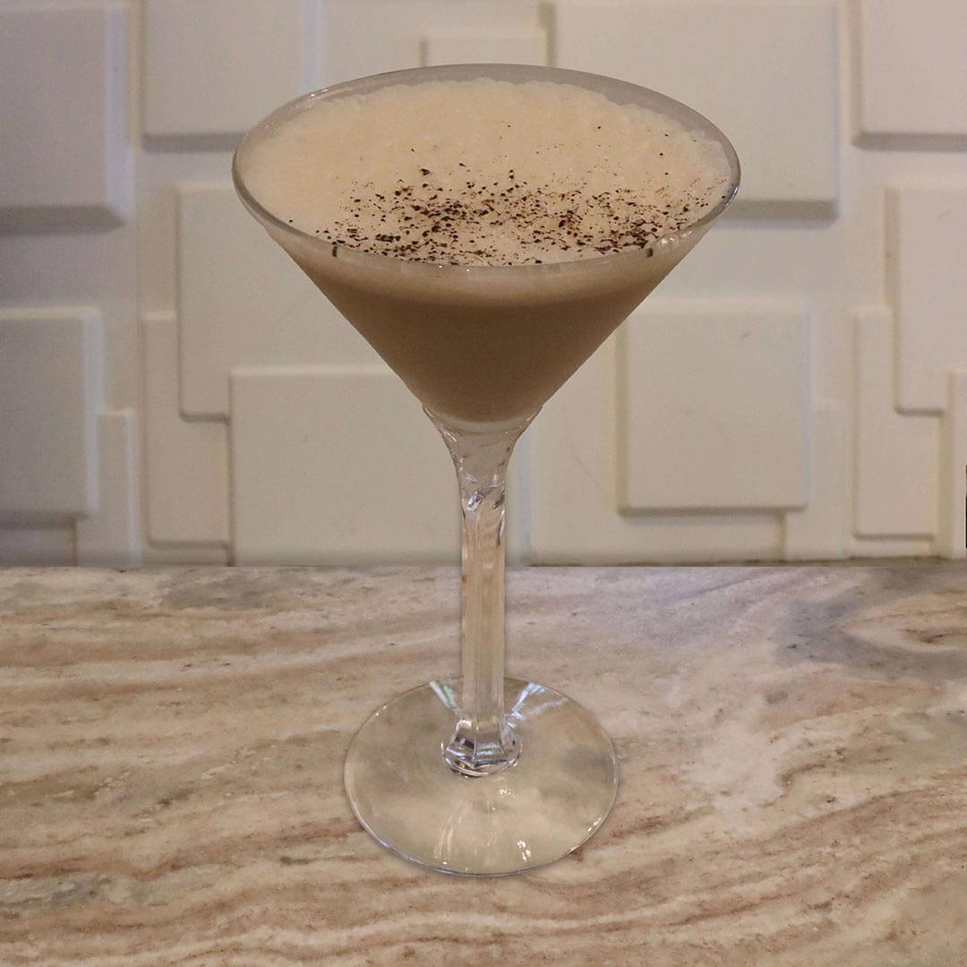 A creamy, light brown coffee cocktail served in a chilled glass.