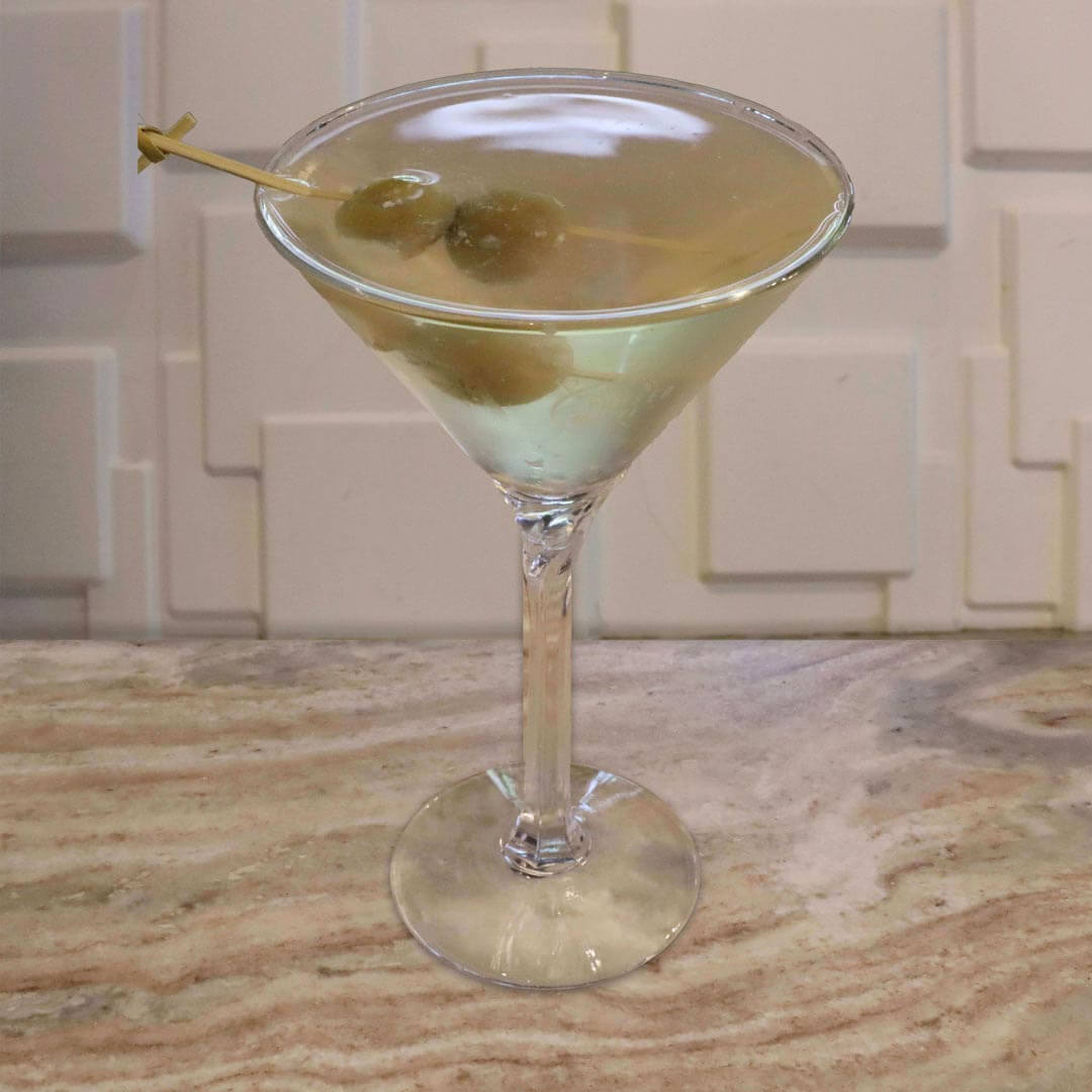 A chilled, clear spirit-forward cocktail prominently garnished with two green olives.