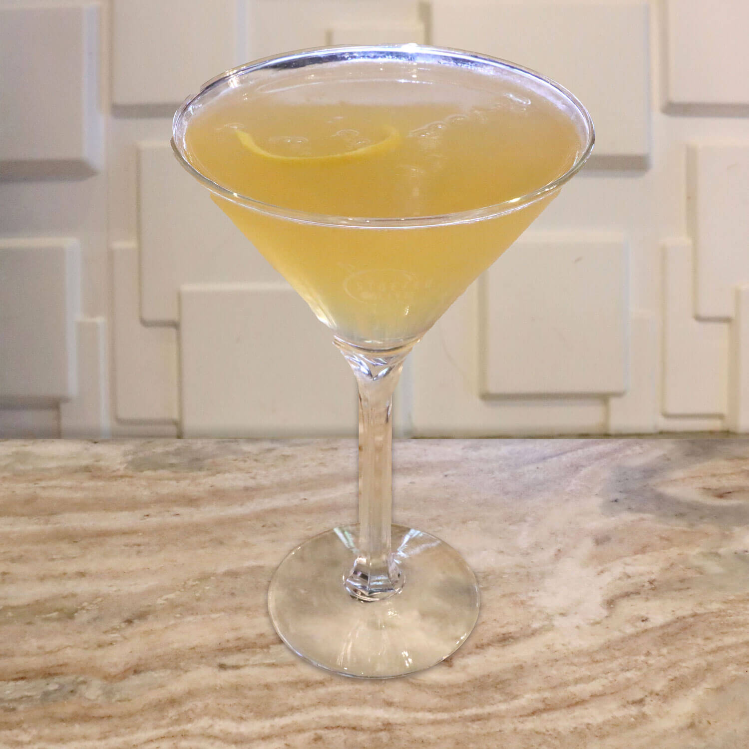 Jose Cuervo, Bärenjäger Liqueur, and Lemon Juice. Garnished With a Lemon Twist