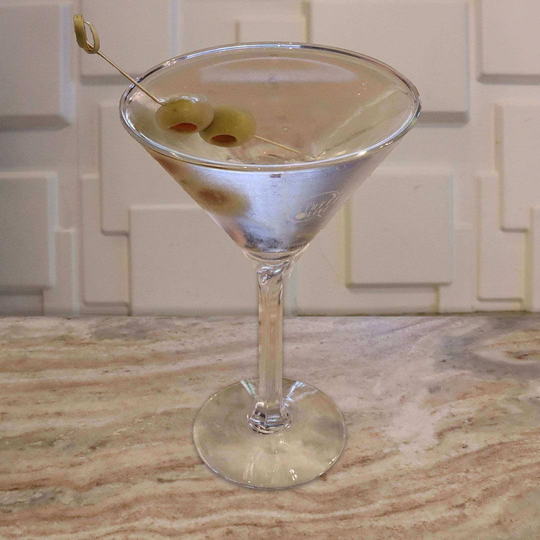 A crystal clear cocktail garnished with two green olives on a pick.