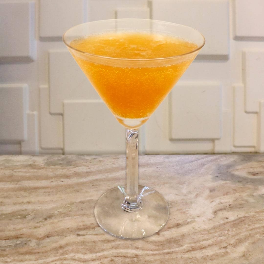 A bright, sparkling orange cocktail served in a classic glass, featuring a highly effervescent texture.