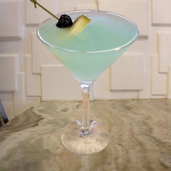Hpnotiq, Malibu Rum, Splash of Pineapple Juice. Garnished With a Pineapple Slice and Luxardo Cherry