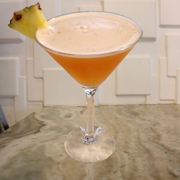 Lemon, Lime, and Basil Muddled in Simple Syrup. Mango Habanero Whiskey, Aperol, St. Germain, and Splashes of Pineapple and Orange Juices. Garnished With a Pineapple Slice